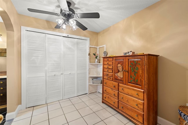 bedroom with ceiling fan, a closet, and light tile patterned floors