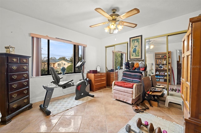 workout room with light tile patterned floors and ceiling fan