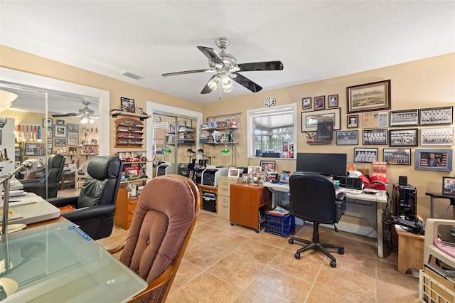 tiled office space featuring a textured ceiling and ceiling fan