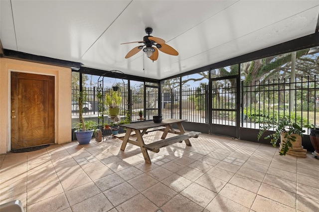 unfurnished sunroom featuring ceiling fan