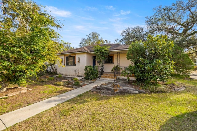 view of front of property with a porch, a front lawn, and stucco siding