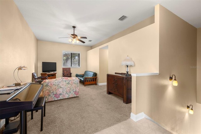 living area featuring a ceiling fan, carpet, visible vents, and baseboards