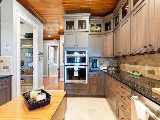 kitchen featuring butcher block counters, decorative backsplash, wooden ceiling, and stainless steel double oven