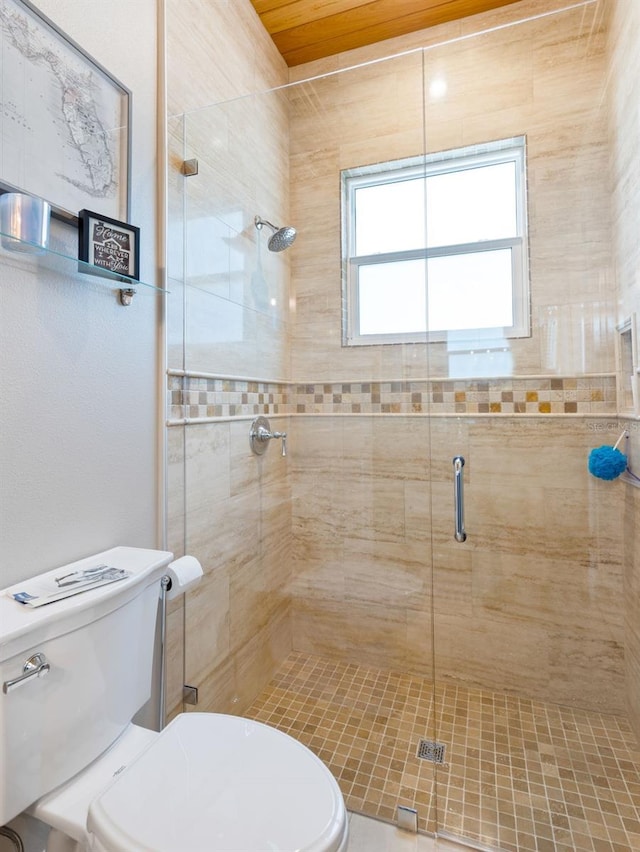 bathroom featuring toilet and a shower with door