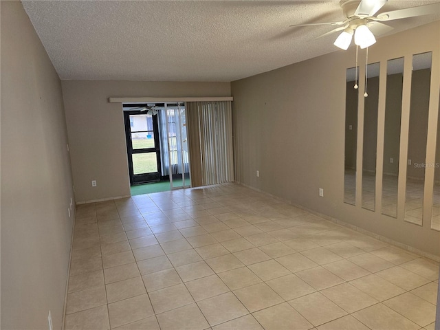 tiled empty room featuring ceiling fan and a textured ceiling