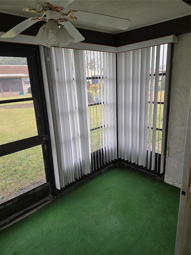 unfurnished sunroom with ceiling fan