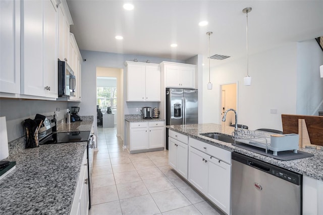 kitchen with sink, hanging light fixtures, stainless steel appliances, light stone countertops, and white cabinets