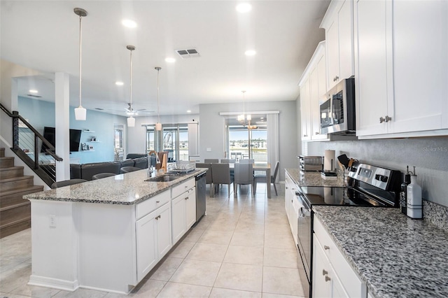 kitchen featuring stainless steel appliances, white cabinetry, a kitchen island with sink, and pendant lighting