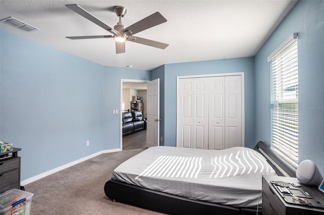 carpeted bedroom featuring a textured ceiling, a closet, and ceiling fan