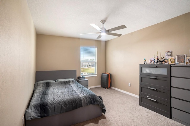 bedroom featuring a textured ceiling, light colored carpet, and ceiling fan