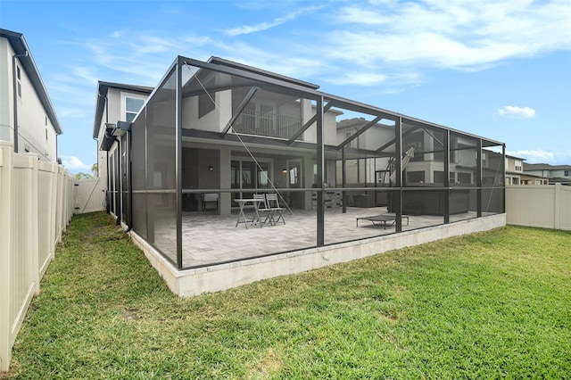 back of house with a yard, a patio, and glass enclosure