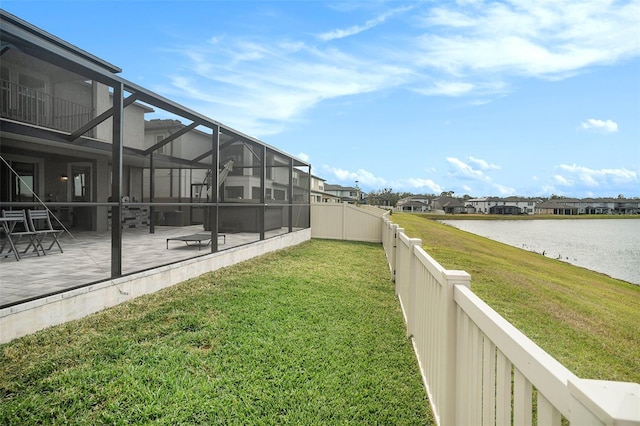 view of yard featuring a water view, glass enclosure, and a patio area