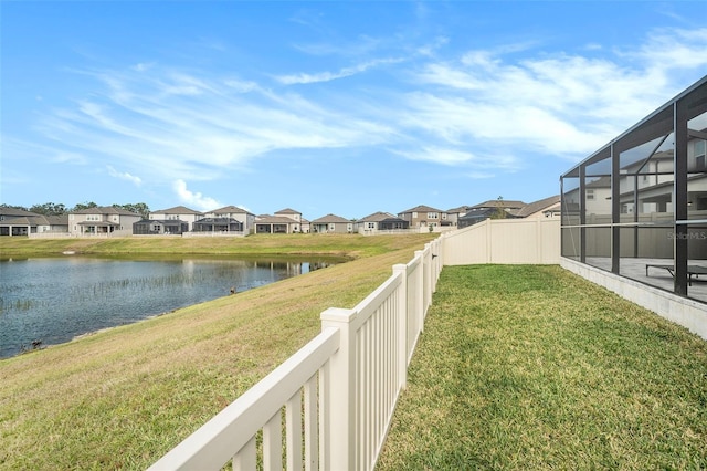 view of yard with a lanai and a water view