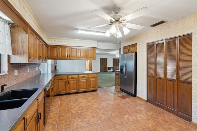 kitchen featuring tasteful backsplash, black dishwasher, sink, ceiling fan, and stainless steel fridge with ice dispenser