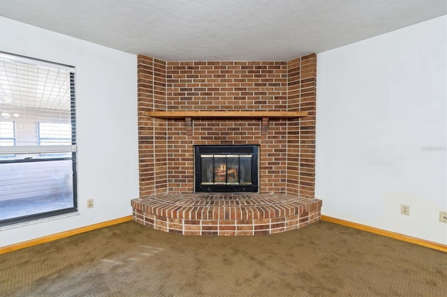 unfurnished living room with a brick fireplace and carpet