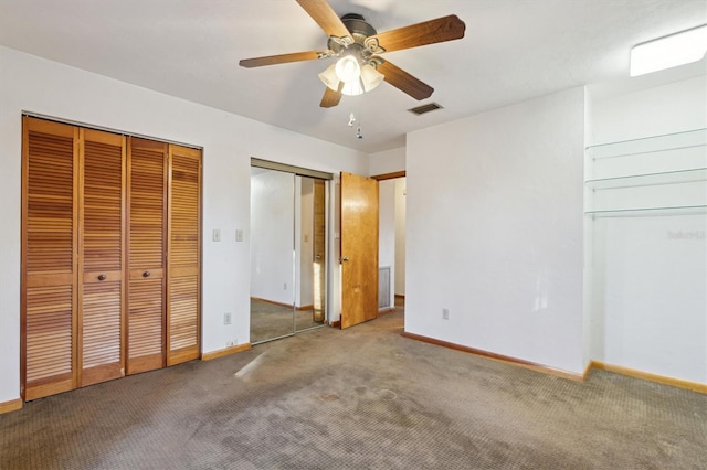 unfurnished bedroom featuring ceiling fan, carpet floors, and two closets