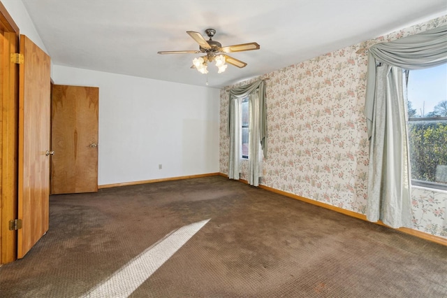 unfurnished room featuring dark carpet and ceiling fan