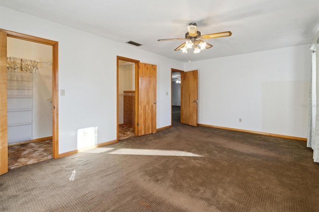 unfurnished bedroom featuring ceiling fan, a walk in closet, and a closet