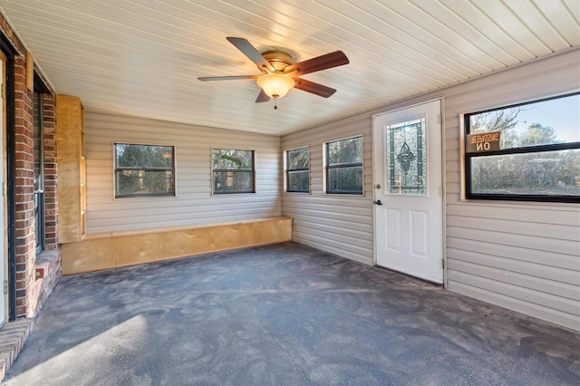 unfurnished sunroom featuring wooden ceiling and ceiling fan