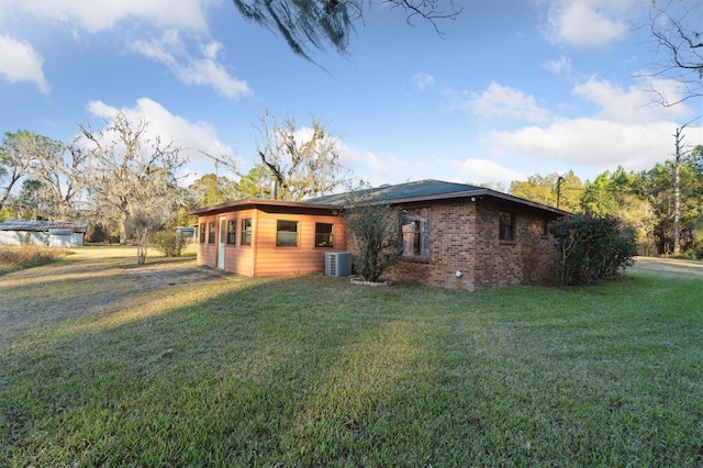 exterior space with central AC and a front yard