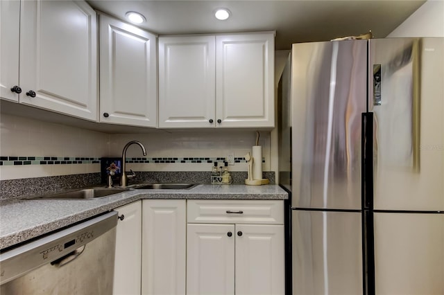 kitchen featuring tasteful backsplash, stainless steel appliances, sink, and white cabinets