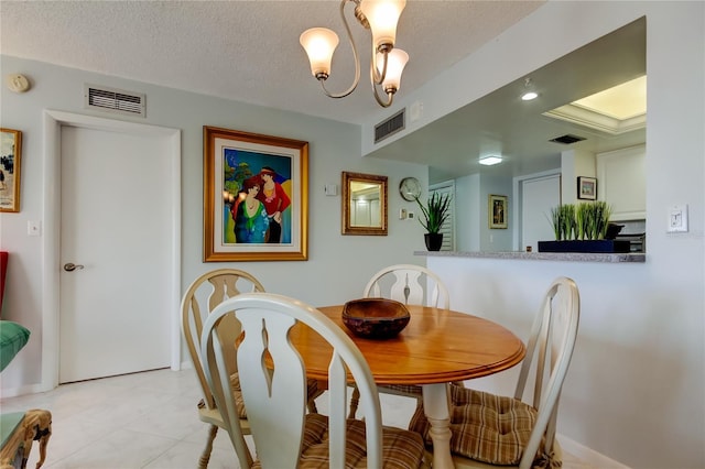 tiled dining space with a notable chandelier and a textured ceiling