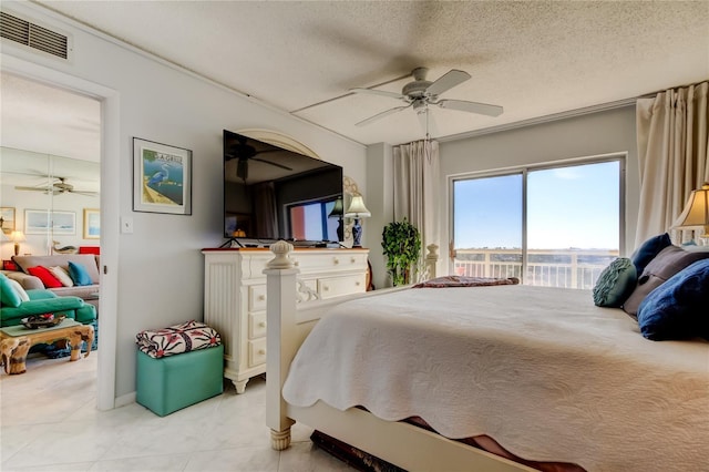 bedroom featuring ceiling fan, access to exterior, and a textured ceiling