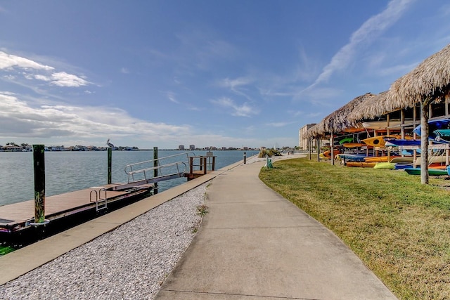 view of dock with a water view and a yard