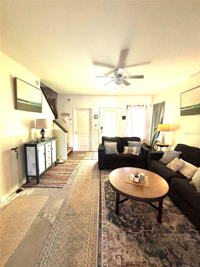 living room with ceiling fan and a textured ceiling