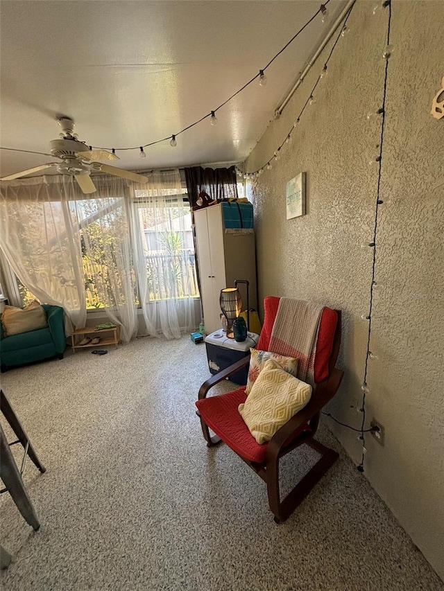 sitting room with ceiling fan and carpet