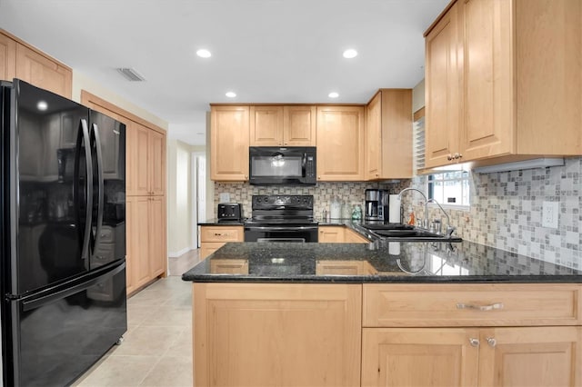 kitchen with light brown cabinetry, black appliances, sink, dark stone counters, and kitchen peninsula