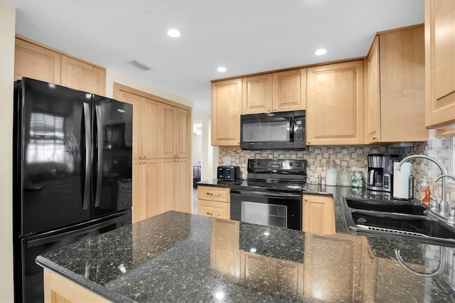 kitchen with light brown cabinetry, sink, black appliances, and dark stone counters