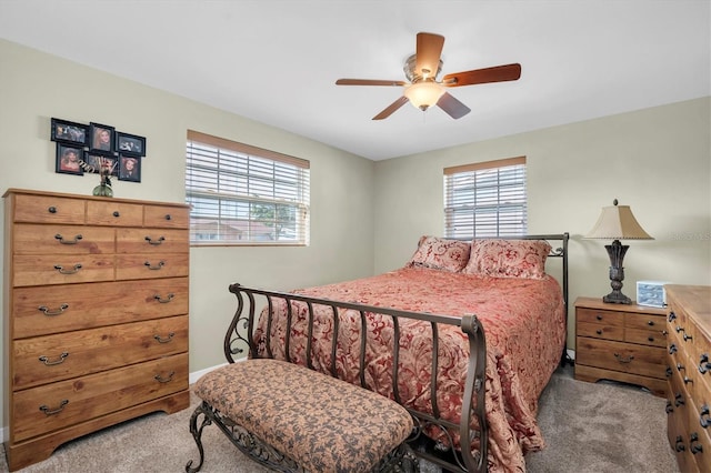 carpeted bedroom featuring multiple windows and ceiling fan