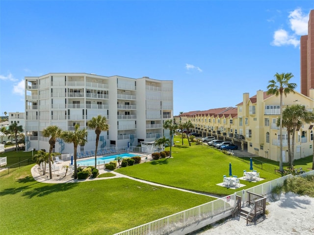 view of building exterior featuring a community pool and fence