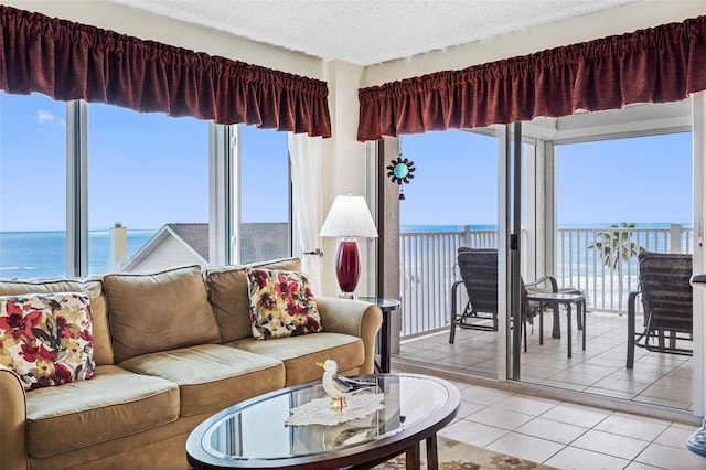 living area featuring light tile patterned floors, a textured ceiling, and a water view