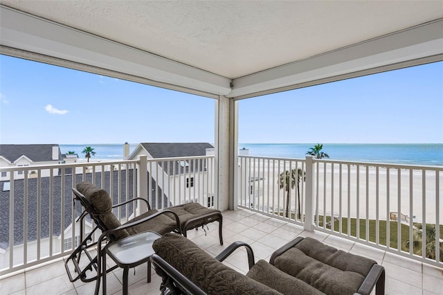 balcony with a water view and a beach view