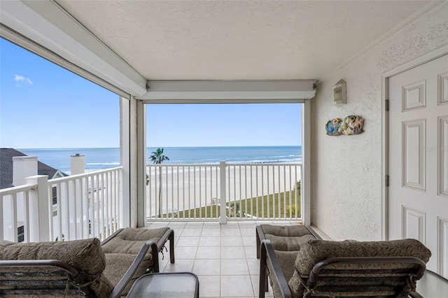 balcony featuring a beach view and a water view