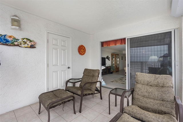 interior space featuring light tile patterned floors, a textured wall, and a textured ceiling