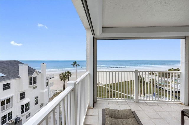 balcony featuring a water view and a beach view