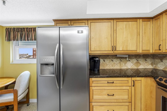 kitchen featuring stainless steel appliances, decorative backsplash, brown cabinetry, a textured ceiling, and dark stone countertops