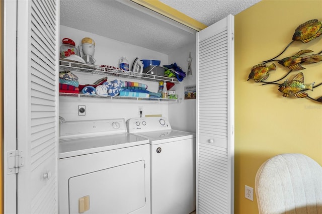 clothes washing area featuring laundry area, washer and clothes dryer, and a textured ceiling