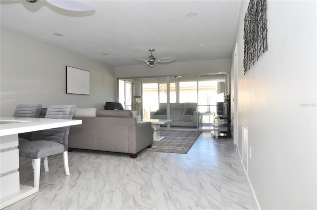 living room with a textured ceiling and ceiling fan