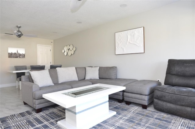 living room featuring ceiling fan and a textured ceiling