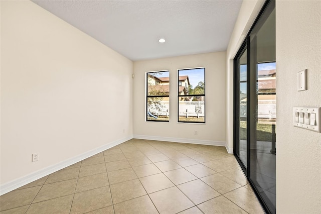 unfurnished room with light tile patterned floors and a textured ceiling