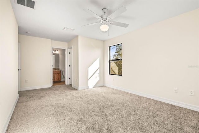 unfurnished bedroom featuring ceiling fan, ensuite bathroom, and carpet