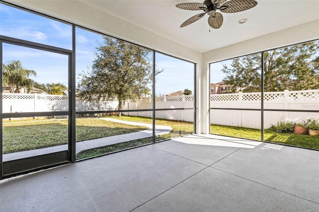 unfurnished sunroom featuring ceiling fan