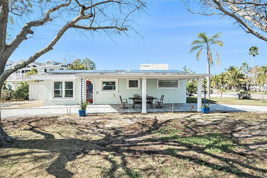 ranch-style home featuring a patio and solar panels