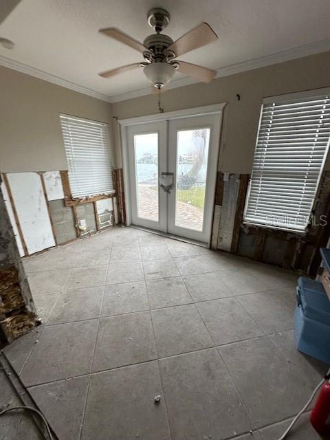 interior space with light tile patterned floors, ornamental molding, french doors, and ceiling fan