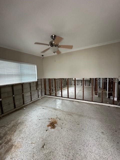 empty room featuring ceiling fan and ornamental molding