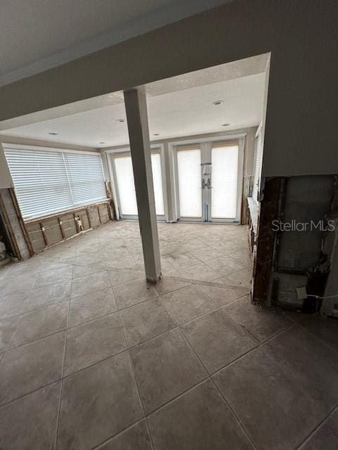 tiled empty room featuring french doors